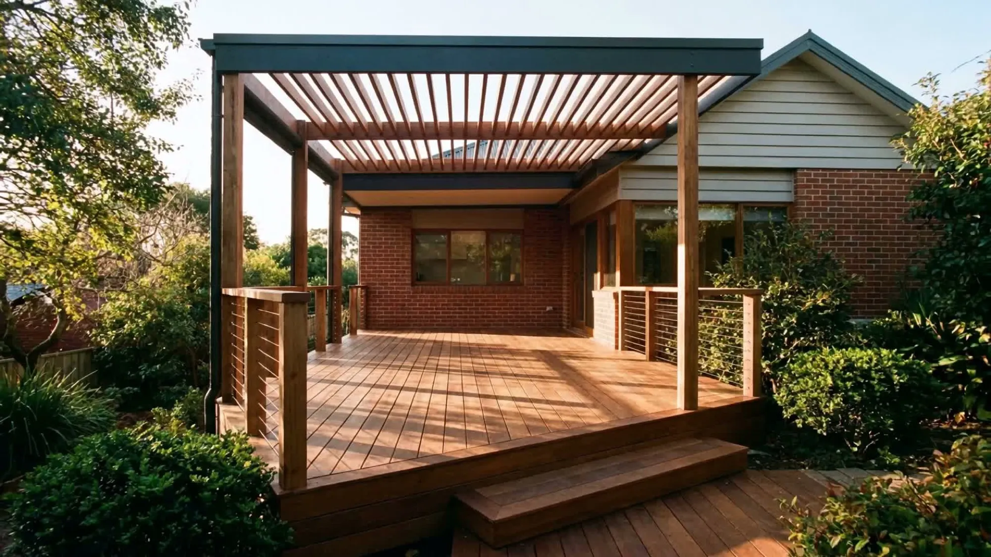 Custom timber pergola over a Merbau hardwood deck at a Melbourne home in golden-hour light, built by BT Built